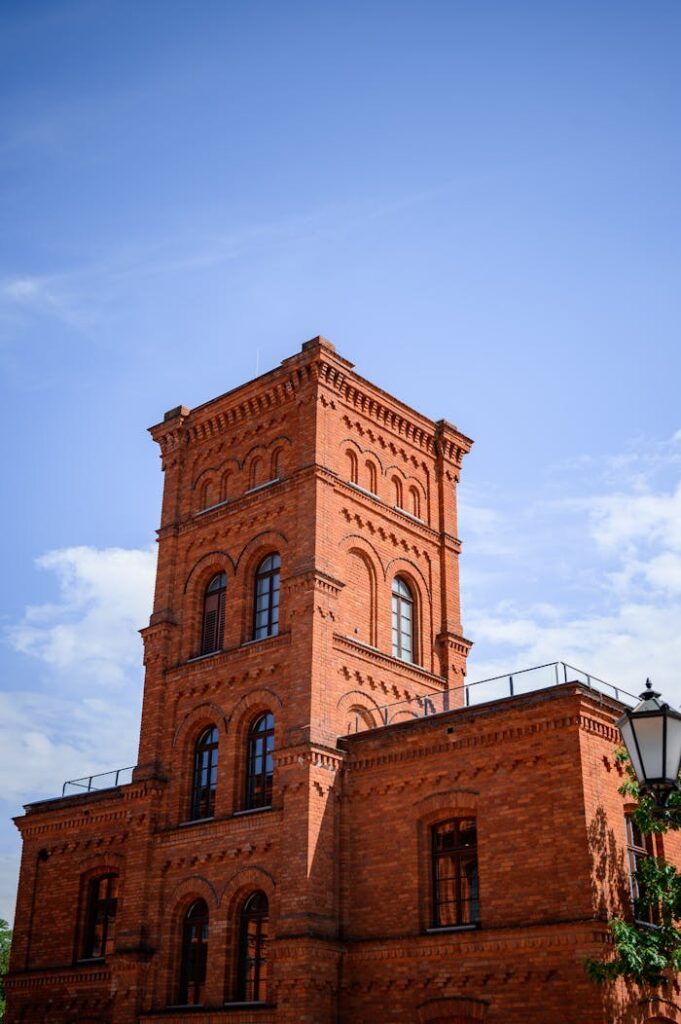 pexels-photo-15596481 Gothic-style brick building in Łódź, showcasing classic architecture against a clear sky.